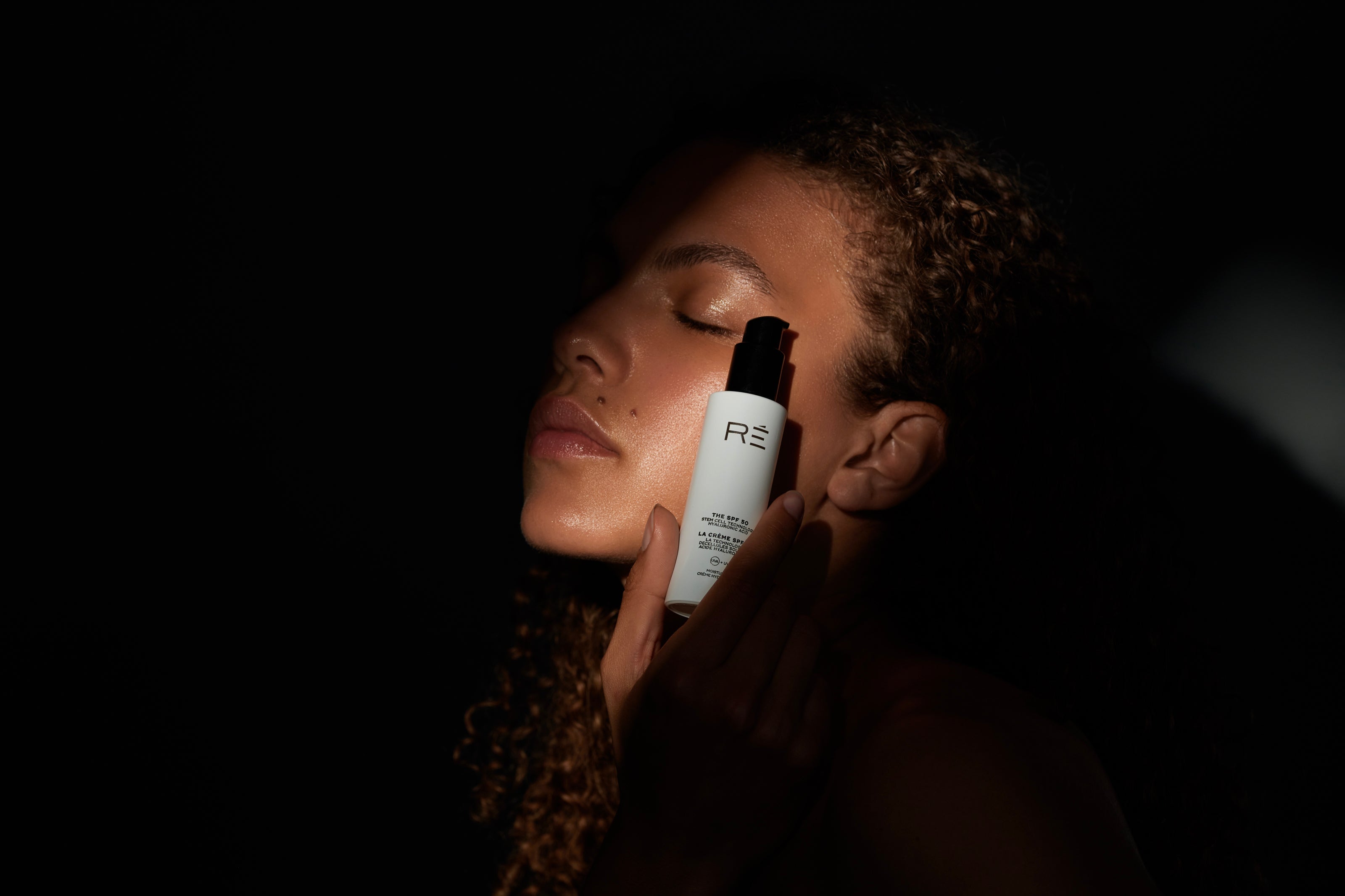 Model holding mineral sunscreen in shadow