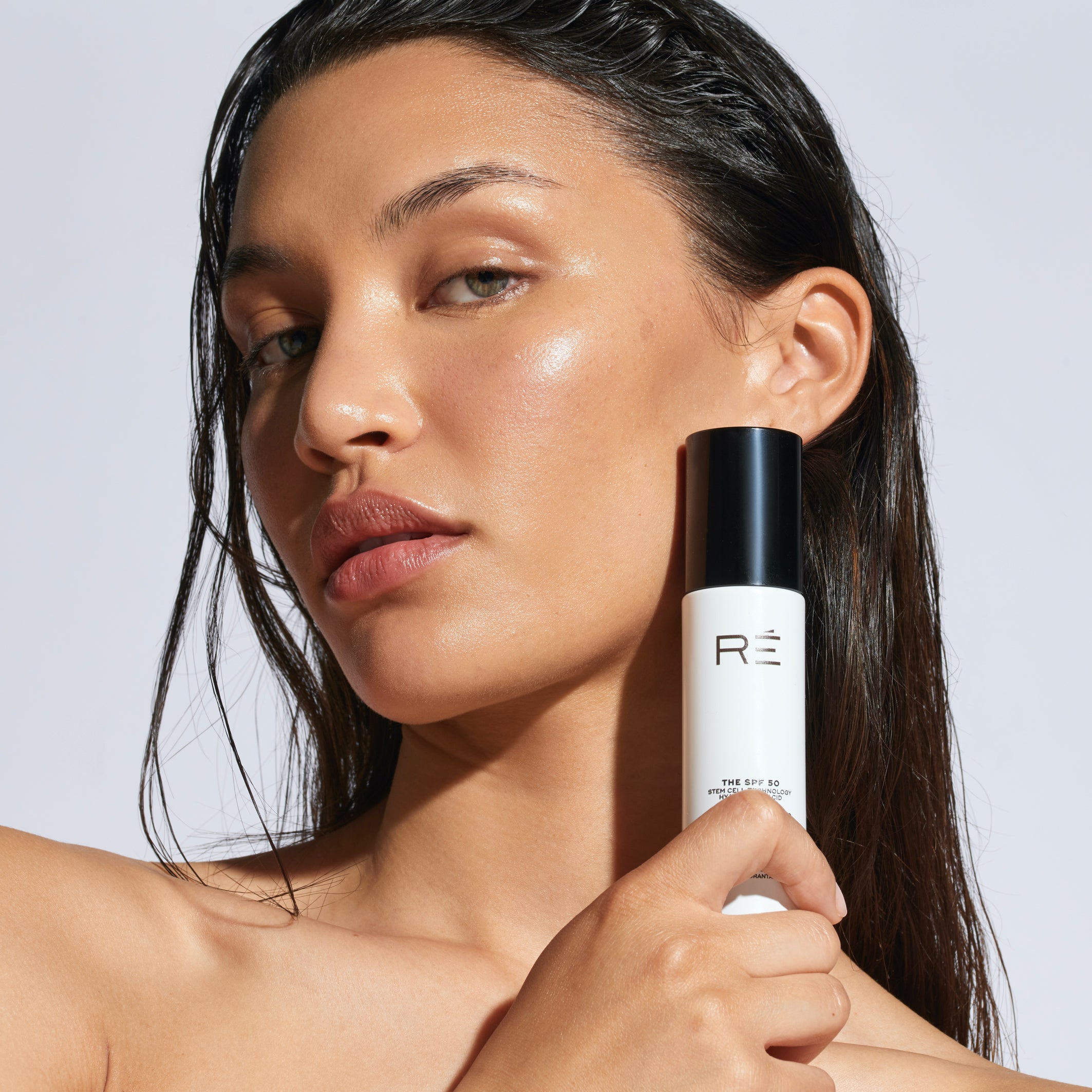 Model holding a sunscreen bottle